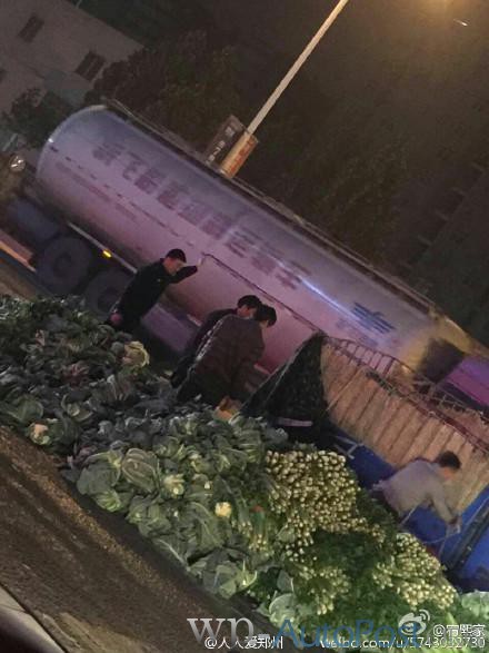 郑州路上菜农意外翻车 警察帮助扶车捡菜